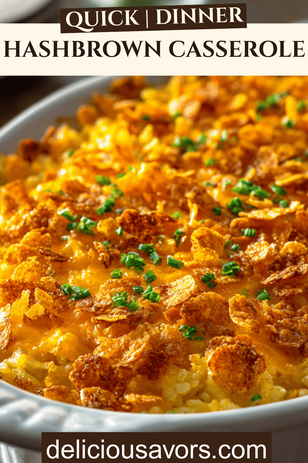 A freshly baked cheesy hashbrown casserole with a crispy cornflake topping in a white dish, perfect for family dinners.