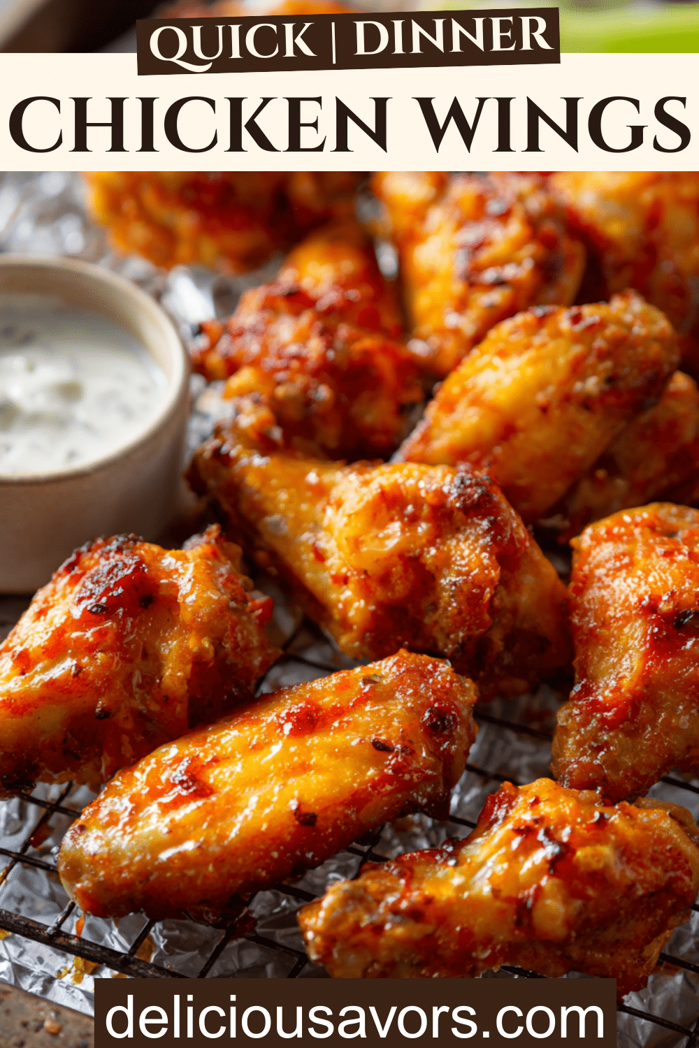 Crispy oven-baked chicken wings glazed with buffalo sauce, served on a wire rack with carrot and celery sticks and ranch dipping sauce.