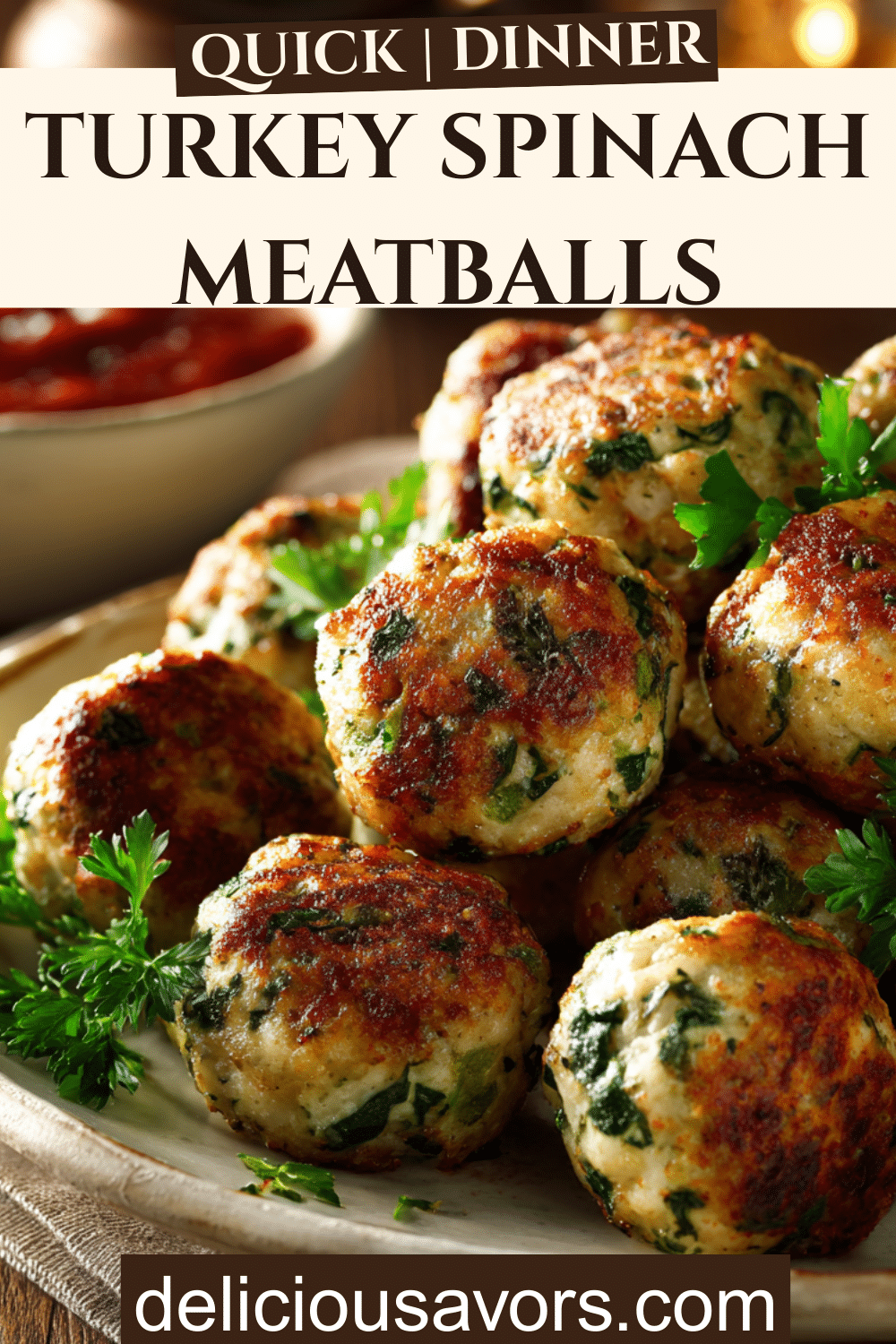 Golden turkey spinach meatballs on white platter with fresh herbs and marinara sauce