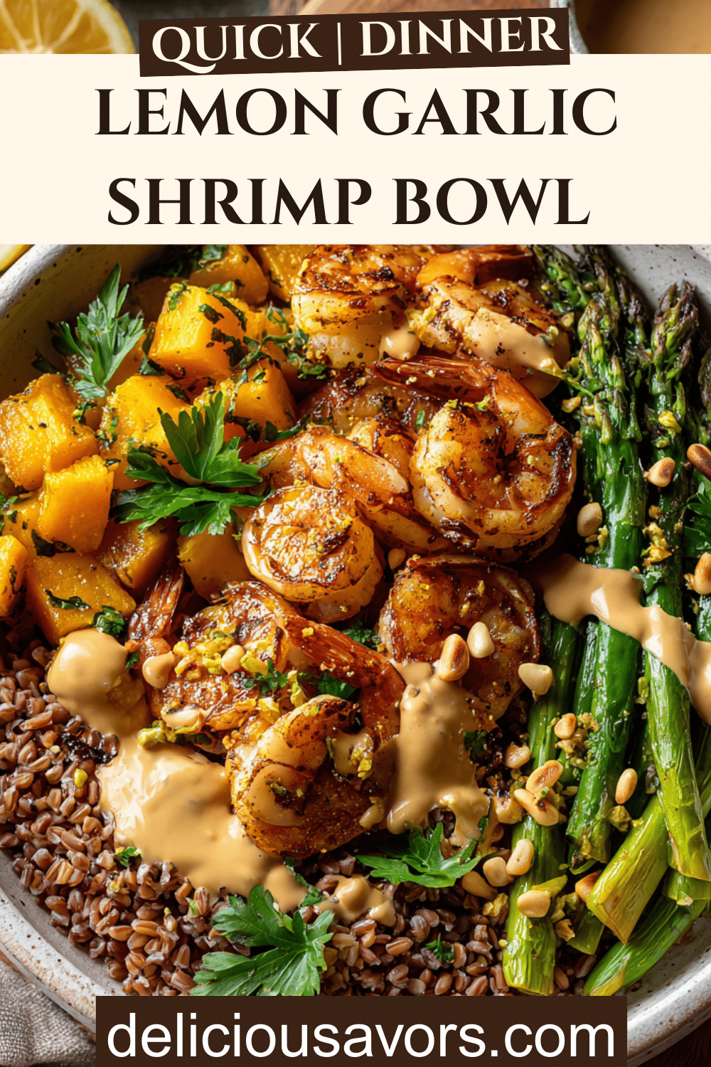 Overhead view of a colorful lemon garlic shrimp bowl with roasted butternut squash, asparagus, farro, and creamy tahini dressing on a white ceramic bowl