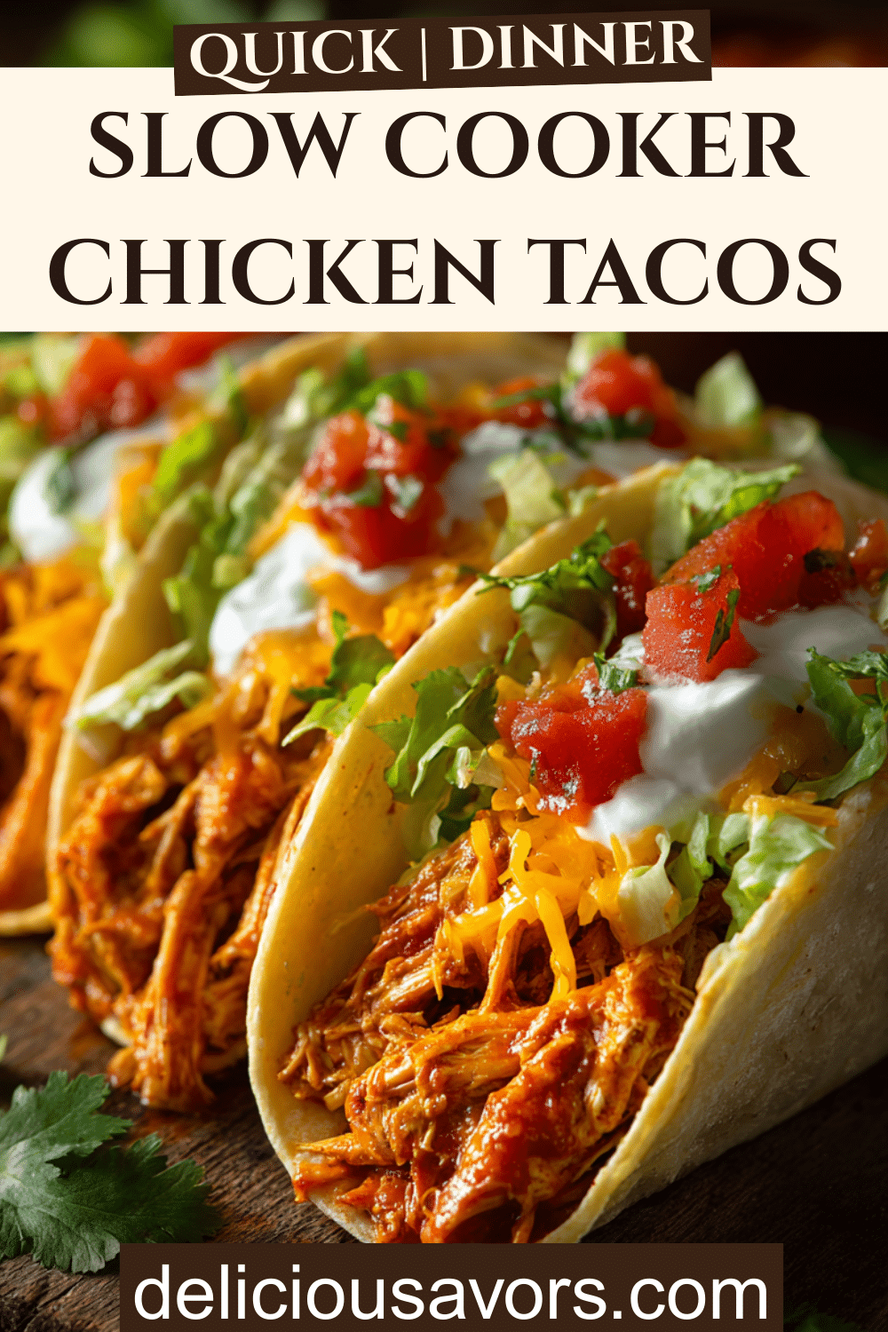 Easy slow cooker chicken tacos with shredded seasoned chicken, lettuce, tomatoes, cheese, and sour cream on flour tortillas