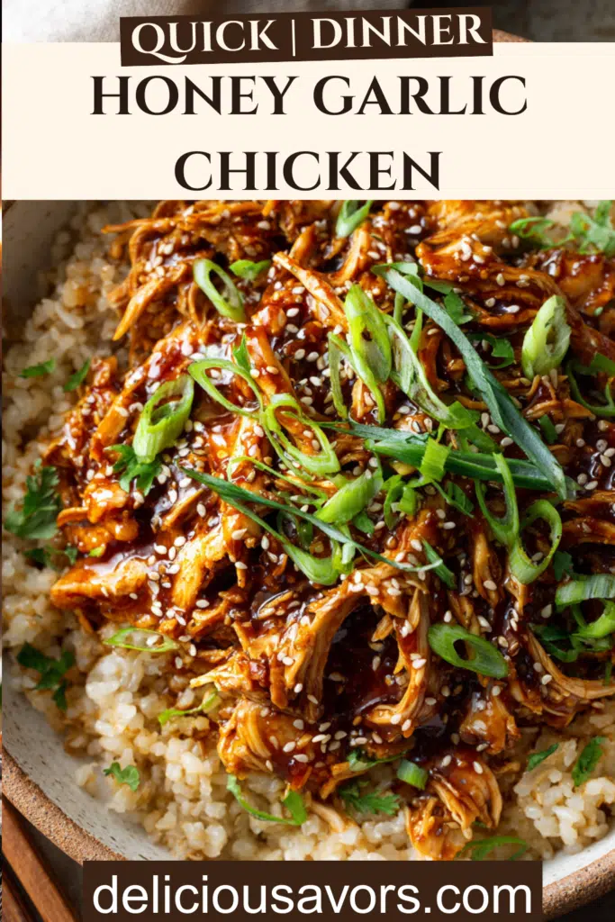 Slow cooker honey garlic chicken served over brown rice with sesame seeds and green onions in a white bowl
