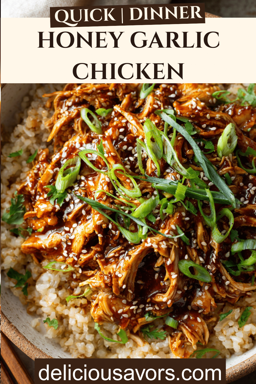 Slow cooker honey garlic chicken served over brown rice with sesame seeds and green onions in a white bowl